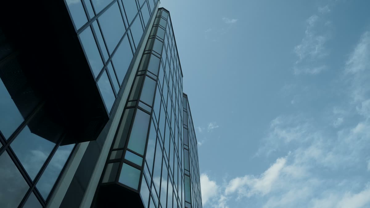 Glasfassade eines Bürohauses vor blauem Himmel